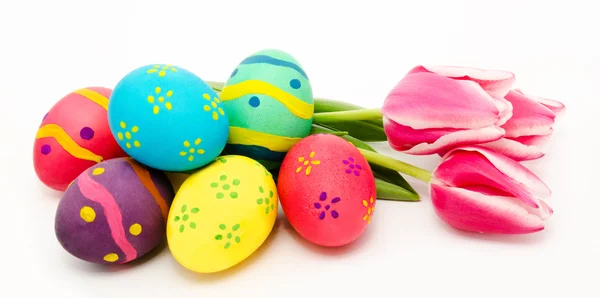 Coloridos huevos de Pascua y flores aisladas en un blanco — Foto de Stock