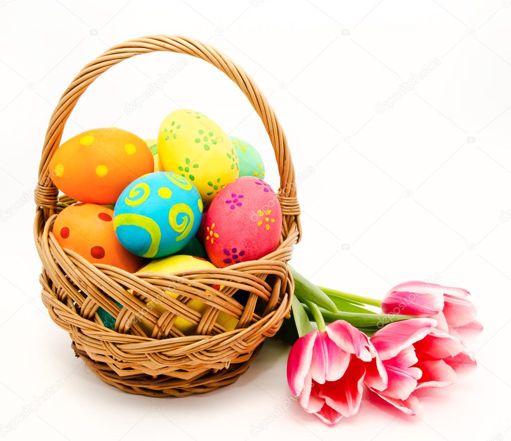 Colorful easter eggs in basket and flowers isolated on a white