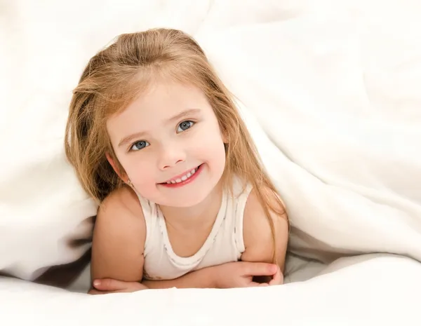 Очаровательная маленькая девочка проснулась в постели — стоковое фото