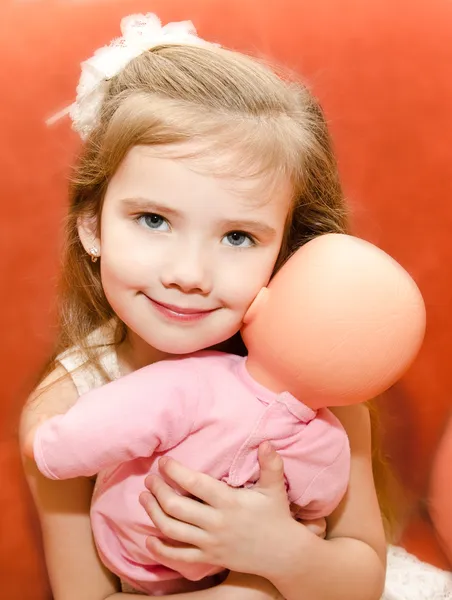 Adorable little girl playing with a doll — Stock Photo, Image