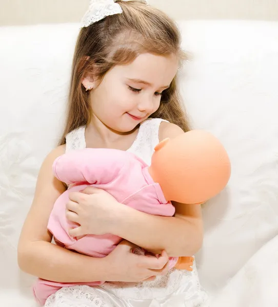 Adorable little girl playing with a doll — Stock Photo, Image