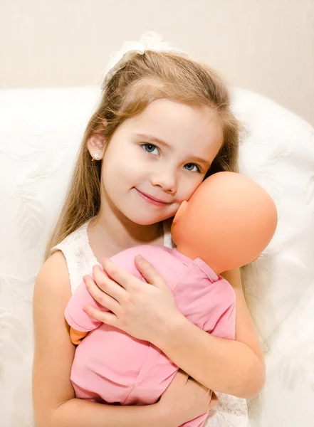 Очаровательная девочка играет с куклой — стоковое фото