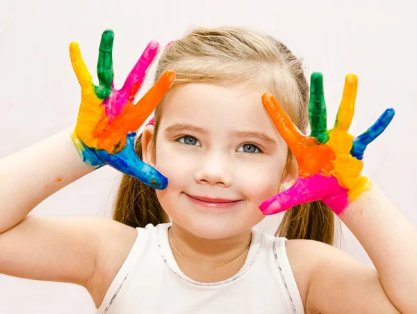 Linda niña sonriente con las manos en pintura — Foto de Stock