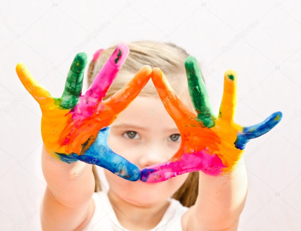 Cute little girl with hands in paint