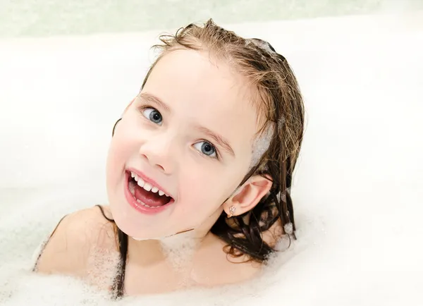 Lachende meisje wassen in het bad met schuim — Stockfoto