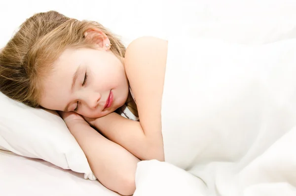 Egy kislány alszik az ágyában. — Stock Fotó