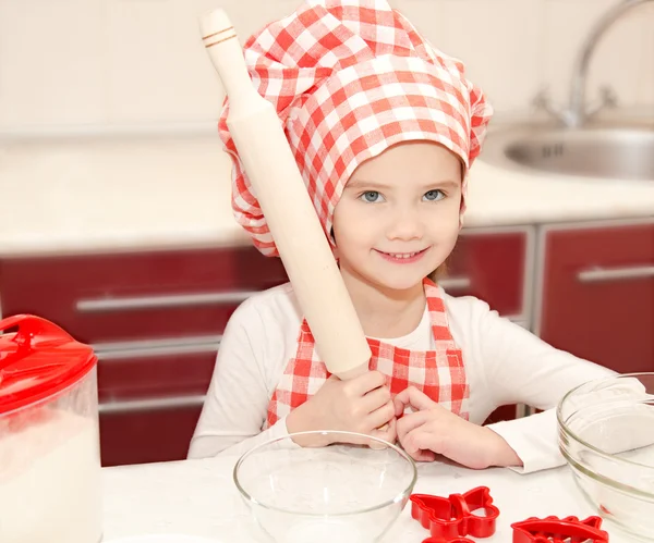 Leende liten flicka med kock hat förbereder sig för att laga mat — Stockfoto