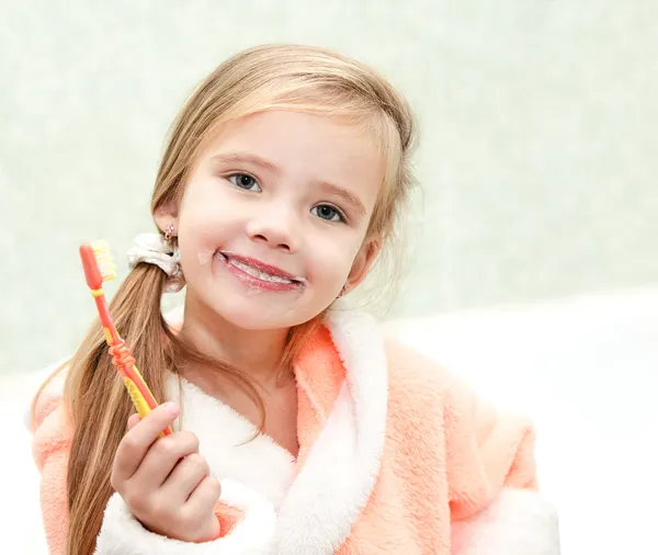 Linda niña cepillarse los dientes en el baño — Foto de Stock