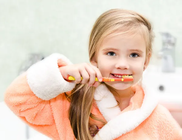 Linda niña cepillarse los dientes en el baño — Foto de Stock