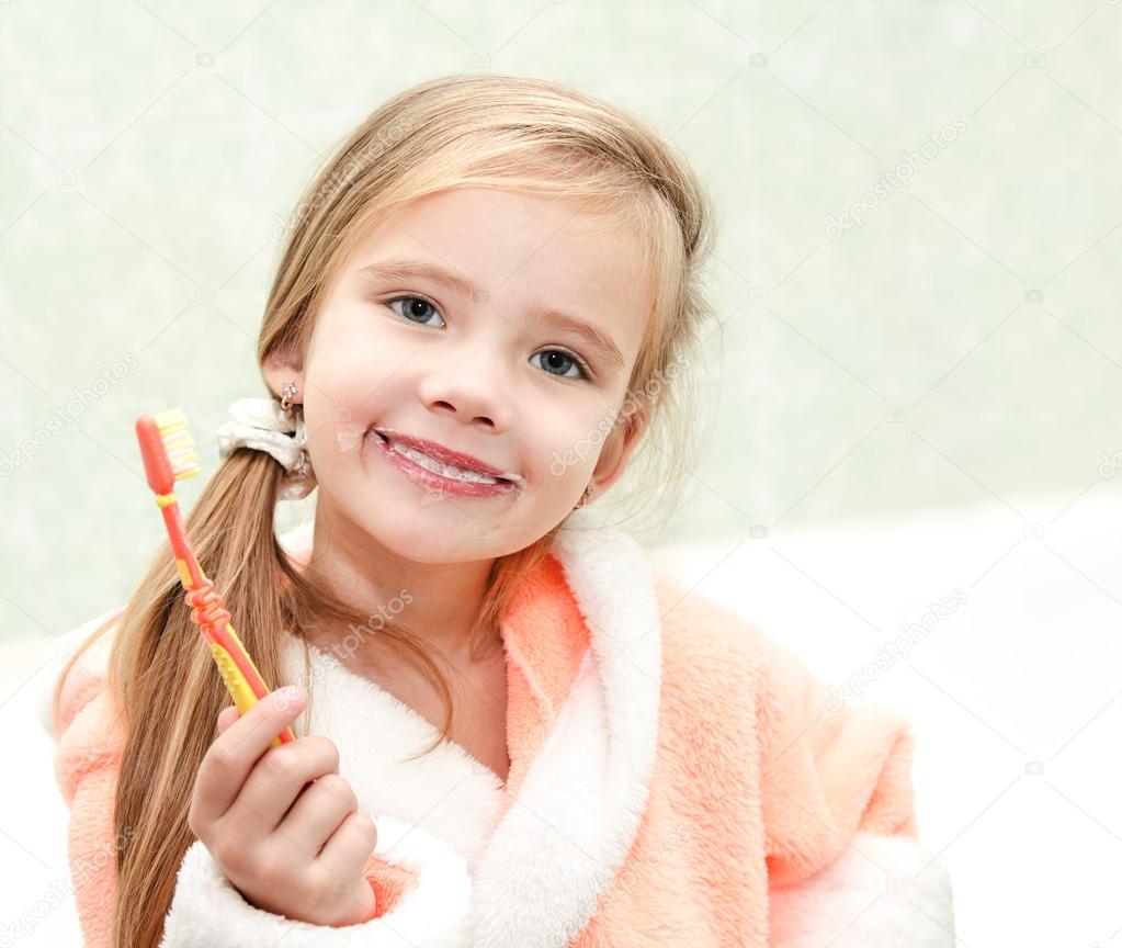Cute little girl brushing teeth in bath 