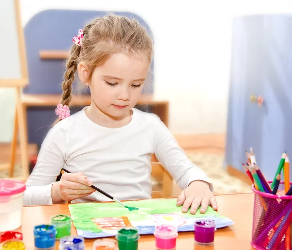 Маленькая девочка рисует краской и кистью — стоковое фото