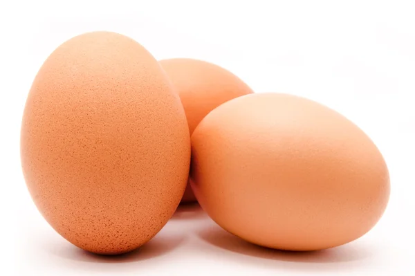 Tres huevos de pollo marrón aislados sobre un fondo blanco — Foto de Stock