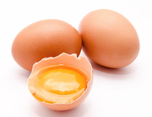 Broken and whole chicken eggs with yolk isolated — Stock Photo, Image