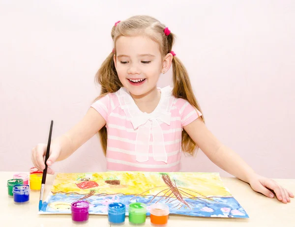 Linda niña sonriente dibujando con pintura y pincel — Foto de Stock