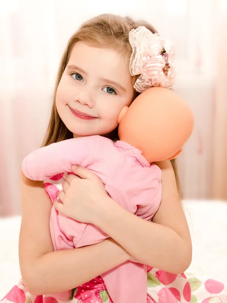 Adorable smiling little girl playing with a doll — Stock Photo, Image