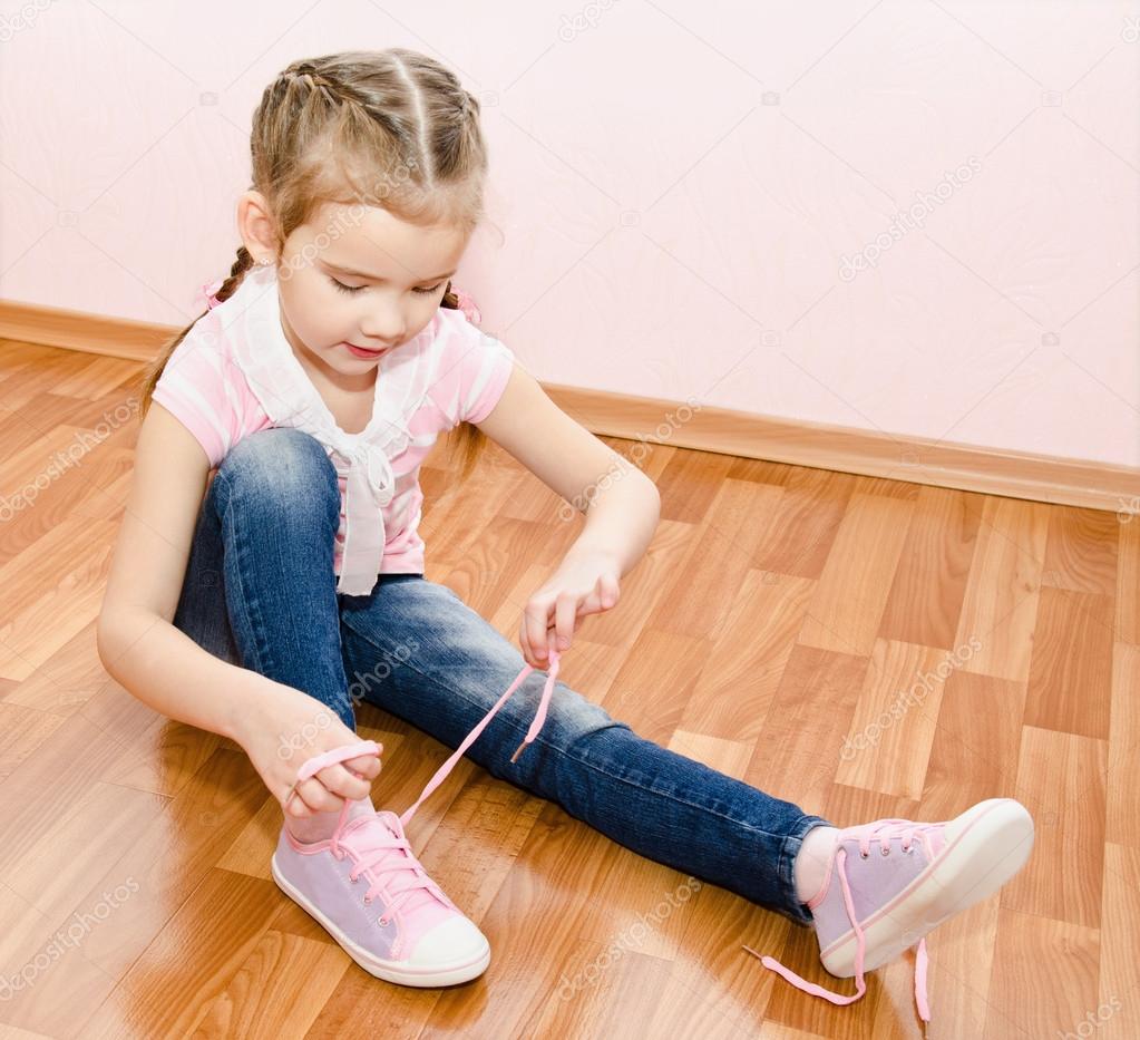 Cute little girl tying her shoes