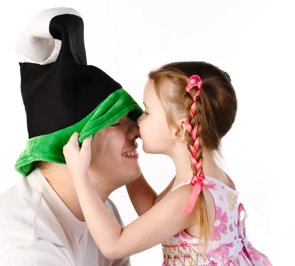 Menina beijando seu pai em boné engraçado isolado — Fotografia de Stock