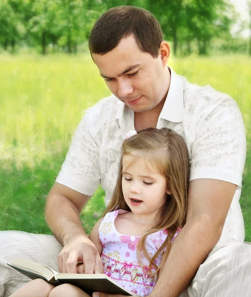 Baba ile kızı parkta okuma — Stok fotoğraf