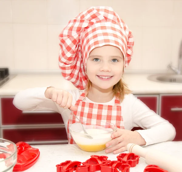 Leende liten flicka med kock hat stirrring cookie deg — Stockfoto