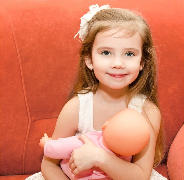 Adorable little girl playing with a doll — Stock Photo, Image