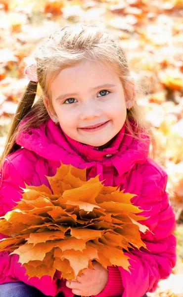 Podzimní portrét roztomilý usměvavá holčička s Javorové listy — Stock fotografie