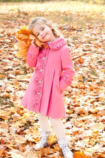 Höst porträtt av söta leende liten flicka med lönn löv — Stockfoto