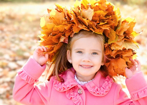 Autumn portrait of smiling little girl in maple wreath — Stock Photo, Image