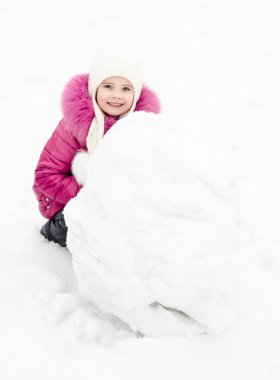 sevimli gülümseyen küçük kız kardan adam kış günü yapar.