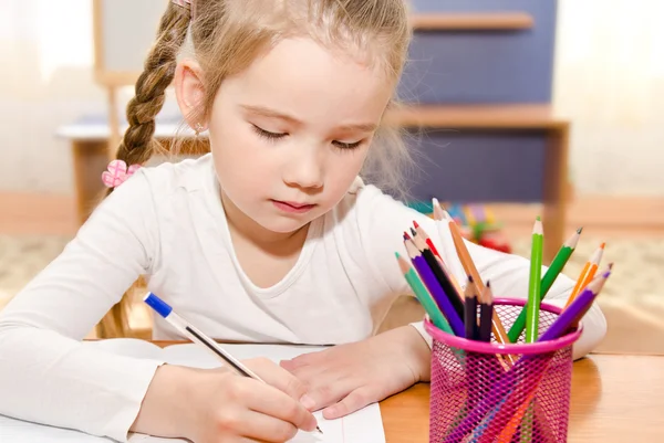 Linda niña está escribiendo en el escritorio Fotos De Stock Sin Royalties Gratis