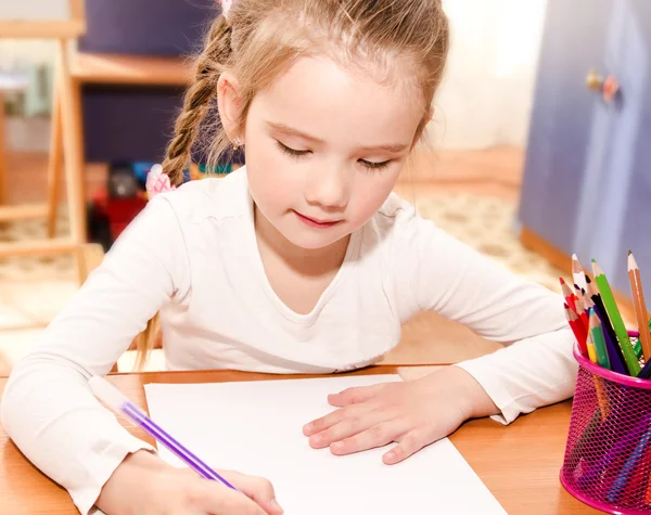 Carina bambina sta scrivendo alla scrivania — Foto Stock