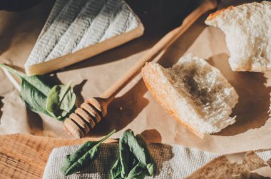 Brie peyniri, kırmızı şarap, bal ve ekmek ile ahşap bir masada akşam yemeği.