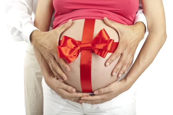 Karın ve babam ellerini etrafında kırmızı yay ile hamile kadın