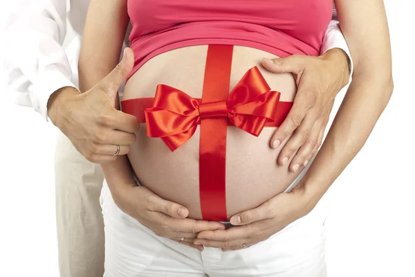 Karın ve babam ellerini etrafında kırmızı yay ile hamile kadın