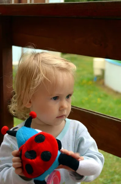 Babymeisje met een stuk speelgoed. — Stockfoto