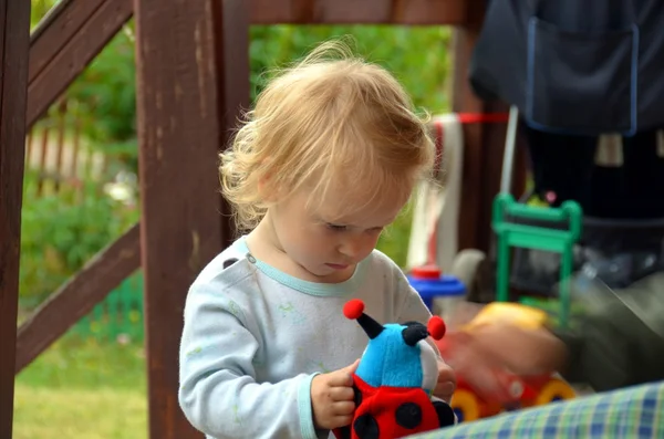 Babymeisje met een stuk speelgoed. — Stockfoto