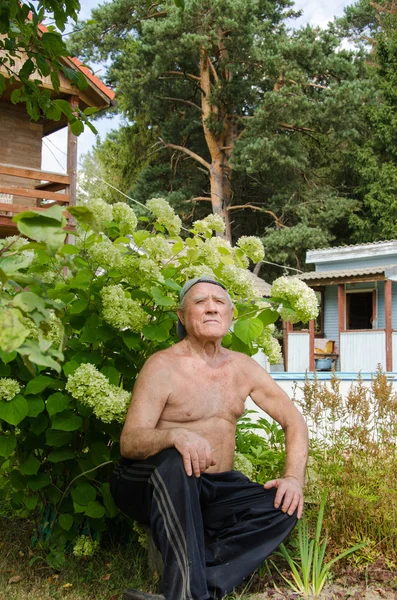 O homem idoso tem um resto em um jardim — Fotografia de Stock