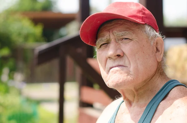 An elderly man in a red baseball cap — Stock Photo, Image