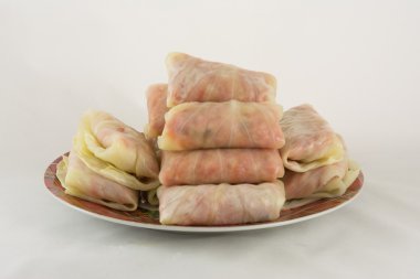 beyaz zemin üzerinde bir tabakta lahana rulo