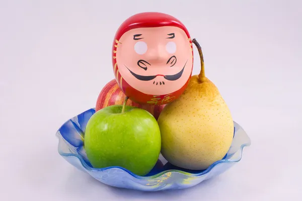 Un bol de fruits et une tête de statuette Samouraï — Photo