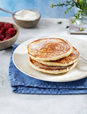 Kahvaltı için krep, ekşi krema, ahududu reçeli ve taze ahududu..