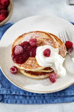 Kahvaltı için krep, ekşi krema, ahududu reçeli ve taze ahududu..