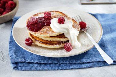 Kahvaltı için krep, ekşi krema, ahududu reçeli ve taze ahududu..