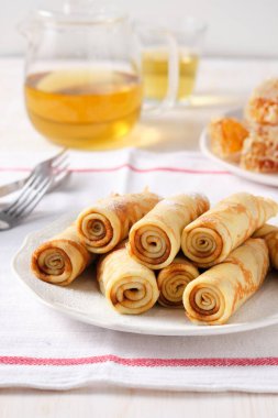 Krep, ballı ince krep ve beyaz tabakta çay..