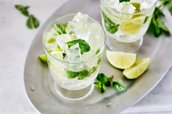 Mojito freddo rinfrescante estate limonata in un bicchiere su uno sfondo grigio cemento o pietra. Copia spazio. — Foto Stock