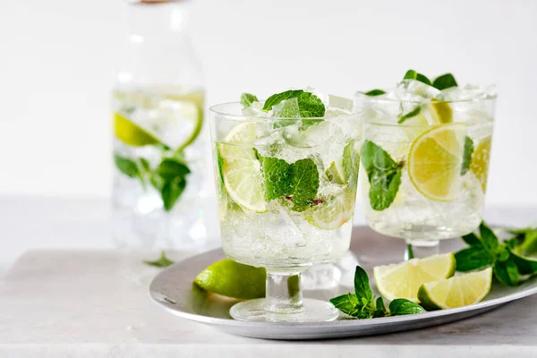 Mojito freddo rinfrescante estate limonata in un bicchiere su uno sfondo grigio cemento o pietra. Copia spazio. — Foto Stock