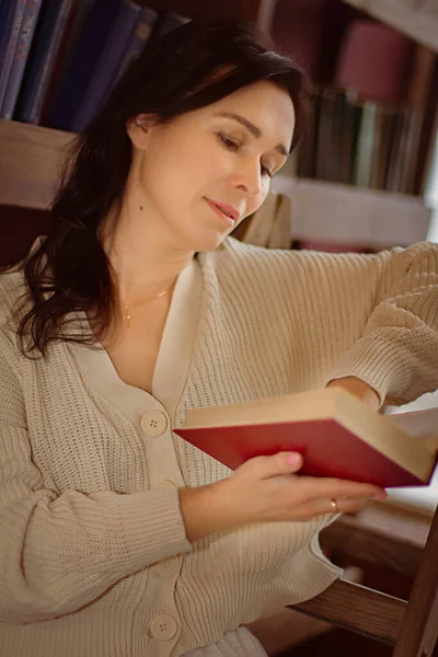 Μια Γυναίκα Στη Βιβλιοθήκη Διαβάζει Ένα Βιβλίο — Φωτογραφία Αρχείου
