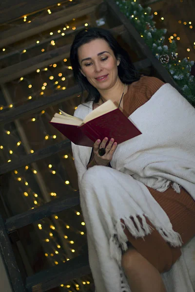 Kütüphanede bir kadın kitap okuyor.