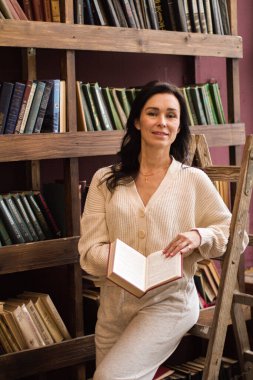 Kütüphanede bir kadın kitap okuyor.