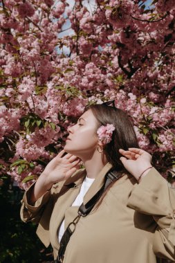 Açık havada romantik bir kadın, arka planda kameraya poz veriyor.