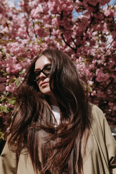 Woman Shaking Her Hair Wind Sakura Blooming Flovers Background — стоковое фото